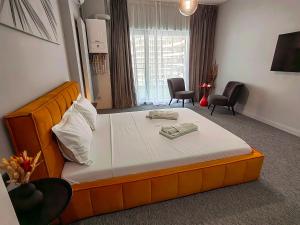 uma cama laranja num quarto com duas cadeiras em The Palm Studio em Mamaia