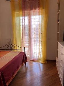 een slaapkamer met een bed en een raam met gordijnen bij Dimora Shimbalaie in Bari
