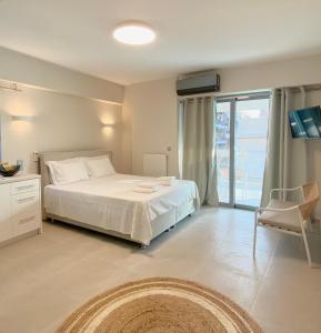 1 dormitorio con cama blanca y balcón en Cottage Boutique Apartments Athens en Atenas