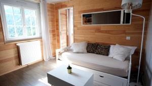 um quarto com um sofá e uma televisão na parede em La Sapinière em Saint-Lary-Soulan