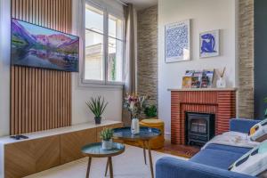 a living room with a couch and a fireplace at Le Balcon des Arts - PrestiPlace Collection in Tours