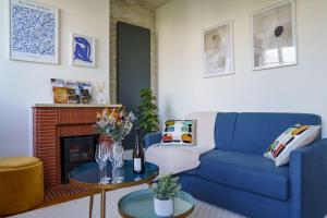 a living room with a blue couch and a table at Le Balcon des Arts - PrestiPlace Tours in Tours