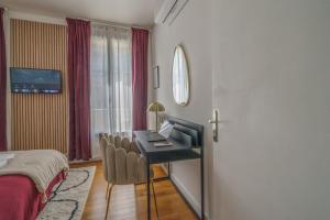 ein Hotelzimmer mit einem Schreibtisch und einem Bett in der Unterkunft Le Balcon des Arts - PrestiPlace Tours in Tours