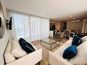 una sala de estar con 2 sofás blancos y una mesa. en The o 5d, En Malecón con vista al mar y lago!, en Mazatlán