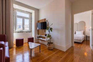 a living room with a bed and a couch and a television at Liberdade Concept 2BDR Apartment by LovelyStay in Lisbon