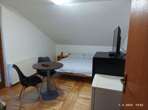 a small room with a bed and a small table and chair at Apartments Dobra Vila in Zlatibor