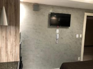 um quarto com uma parede e uma televisão de ecrã plano em HOTEL BIGSTAR em Salvador