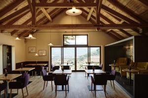 a restaurant with tables and chairs and a large window at Schloss Plars wine & suites in Lagundo