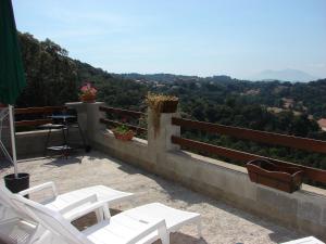 un balcone con sedie bianche e un grill su una collina di Le Gîte Radica a Eccica-Suarella