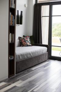 a bedroom with a couch and a book shelf at Utriai Guest Place in Utriai