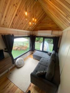 a living room with a couch and a large window at Butka tiny house in Ardeşen