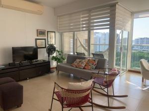 uma sala de estar com um sofá e uma televisão em Santa Marta Apartamento Bello Horizonte Zazué em Santa Marta