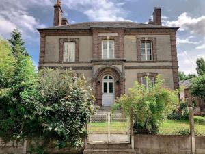 una vecchia casa con un cancello davanti di Gîte au cœur d'une résidence d'artiste a Saint-Aubin-de-Bonneval