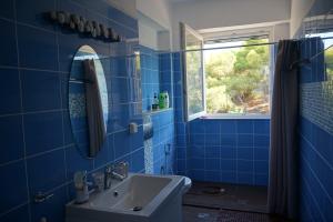a blue bathroom with a sink and a mirror at Villa La Fontaine "Luxury apartment" in Porto Heli