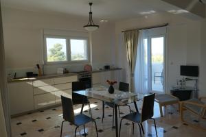 a kitchen with a table and chairs and a dining room at Villa La Fontaine "Luxury apartment" in Porto Heli