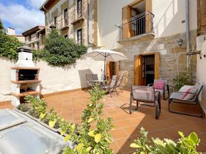 a patio with a table and chairs and an umbrella at Apartamentos Puente La Reina in Puente la Reina