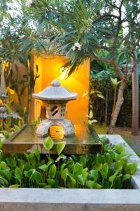 a statue of a person wearing a hat in a garden at Casa de Amistad Guesthouse in Vieques
