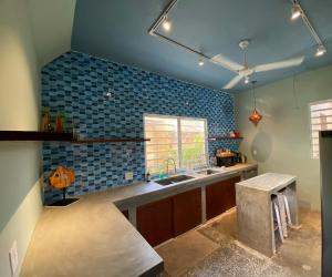 a kitchen with blue tiles on the wall and a sink at Casa de Amistad Guesthouse in Vieques