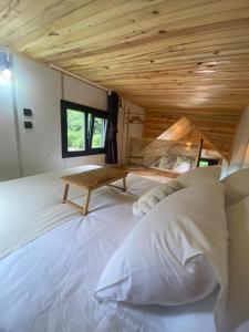 a large white bed in a room with a wooden ceiling at Butka tiny house in Ardeşen