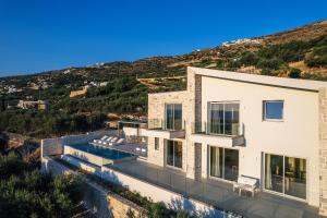 an aerial view of a house with a hill at Petras Resort in Falasarna