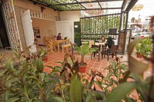 een patio met mensen aan tafels en planten bij 7. Apartamento dentro Cafe hotel in Bogota