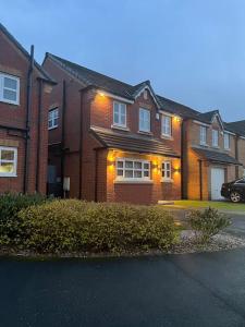 a brick house with a car parked in front of it at Stunning Home in Astley in Tyldesley