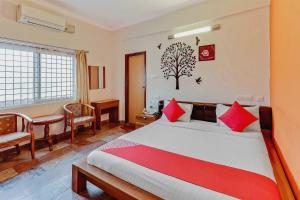 a bedroom with a large bed with red pillows at Goyal Residency in Bangalore