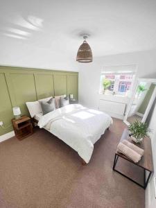 a bedroom with a large white bed and a window at Stunning Home in Astley in Tyldesley
