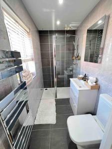 a bathroom with a shower and a toilet and a sink at Stunning Home in Astley in Tyldesley +32 photos