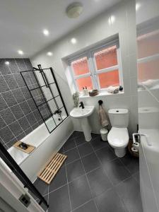 a bathroom with a toilet and a sink at Stunning Home in Astley in Tyldesley