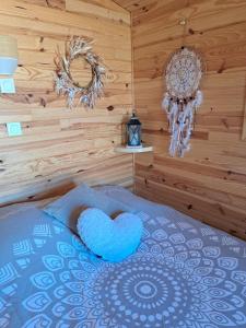 ein Schlafzimmer mit einem blauen Herzkissen auf einem Bett in der Unterkunft Roulotte en bois in Fuveau