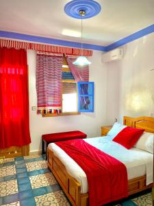 - une chambre avec un lit et des rideaux rouges dans l'établissement Hôtel Al Kalaa, à Chefchaouen