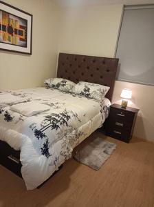 um quarto com uma cama com um edredão preto e branco em Precioso departamento equipado - Cochera incluida em Chila Pampa