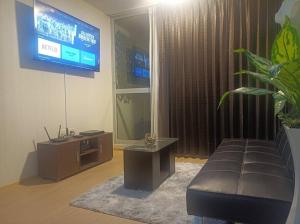 uma sala de estar com um sofá e uma televisão em Precioso departamento equipado - Cochera incluida em Chila Pampa