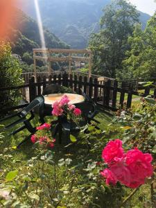 a bench with pink flowers in front of a fence at Haus Granata Family - Trekking - Bike in Giazza