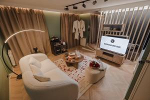 a living room with a white couch and a tv at DISNEY MOOD BY WELOVEYOU® in Bailly-Romainvilliers