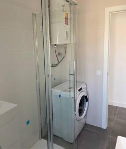 a washer and dryer in a white room with a washing machine at Apartamentos La Gaviota in Roquetas de Mar
