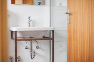 a bathroom with a white sink and a mirror at Kuckucksnest Lenzkirch in Lenzkirch