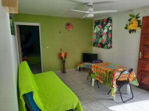 ein Wohnzimmer mit einem Tisch und einer grünen Wand in der Unterkunft La Casa Binecha avec Jacuzzi in Baillif