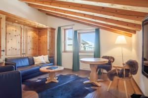 - un salon avec un canapé et une table dans l'établissement Appartments Cervus, à Saint-Moritz
