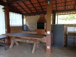 una mesa de madera en una cocina con horno de ladrillo en Casa com churrasqueira piscina privativa em São Pedro da Serra - Perto de Lumiar en Nova Friburgo