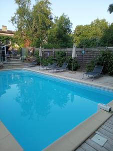 a large swimming pool with chairs and umbrellas at La Girondine in Galgon