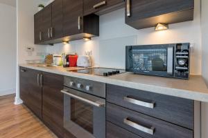 a kitchen with a counter top with a microwave at 1 Bedroom Flat in the Heart of Merchant City in Glasgow
