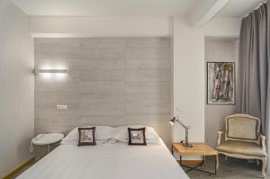 皮耶特拉桑塔的住宿－Hotel Joseph，卧室配有白色的床和椅子