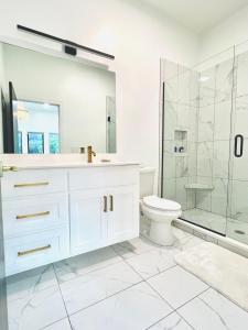 a white bathroom with a shower and a toilet at The Shoal Creek Chateau Lake House in Florence