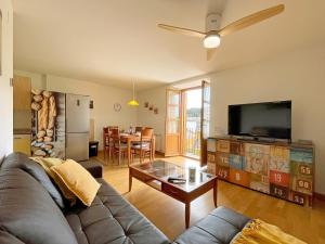 a living room with a couch and a flat screen tv at Apartamentos Puente La Reina in Puente la Reina