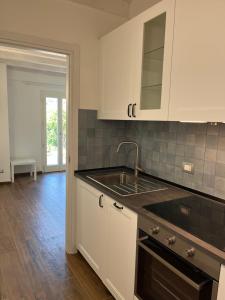 a kitchen with white cabinets and a sink at Nei castagni in Levanto