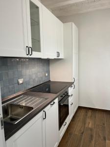 a kitchen with white cabinets and a sink at Nei castagni in Levanto