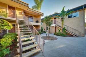 a staircase leading to a building with palm trees at Quiet San Diego Condo with Balcony, Pool, Hot Tub! in San Diego