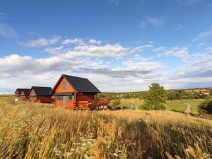 ein Haus auf einem Hügel auf einem Feld in der Unterkunft Jotwingia - Domki z Widokiem in Stare Juchy